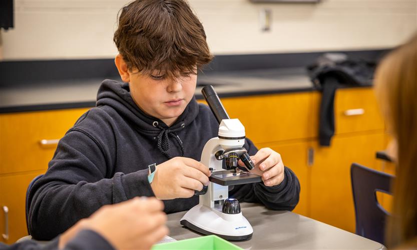 Students use microscopes in science class